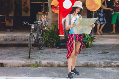 Full length of woman holding bicycle