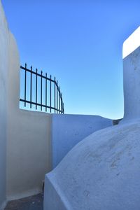 Staircase on wall against clear blue sky