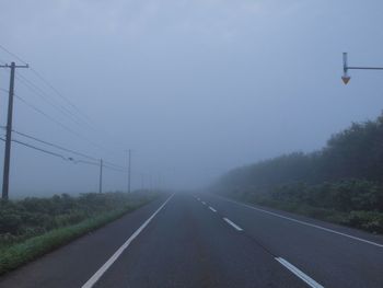 Road amidst trees against sky