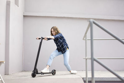 Young woman with electric scooter in a loft