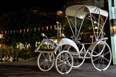 Bicycle parked on illuminated street at night