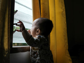 Portrait of boy looking through window