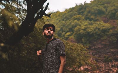 Portrait of young man standing in forest