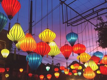 Low angle view of illuminated lanterns hanging against sky