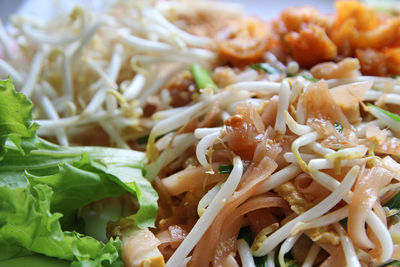 Thailand fried noodles, as pad thai with the chicken, bean sprout, lettuce and green onion