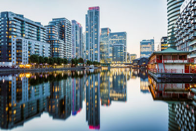 Reflection of buildings in river against sky