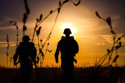 Silhouette army soldiers against sunset