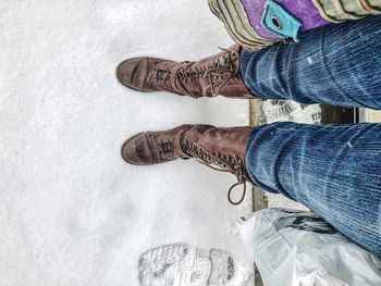 Low section of person standing on snow