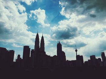 Low angle view of buildings against cloudy sky