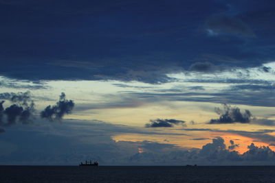 Silhouette people on beach against sky at sunset