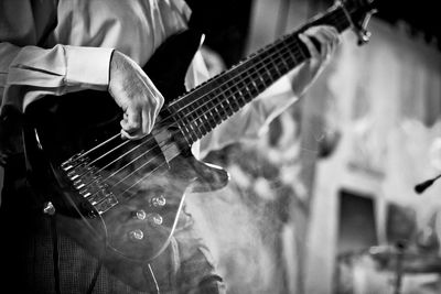 Midsection of man playing guitar