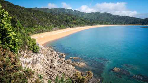 High angle view of sea and mountains against sky