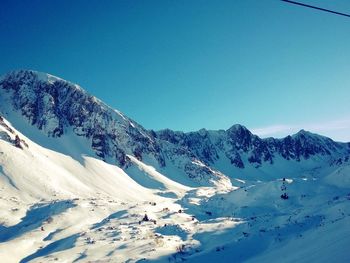 Scenic view of snowcapped mountains against blue sky