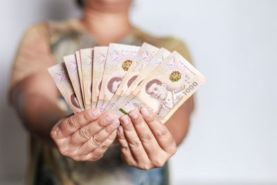 Midsection of woman holding paper currency