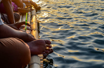 Midsection of woman sitting by sea