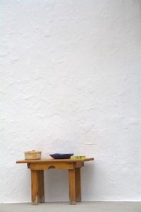 Empty chairs and table against wall