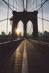 Silhouette brooklyn bridge against sky during sunrise