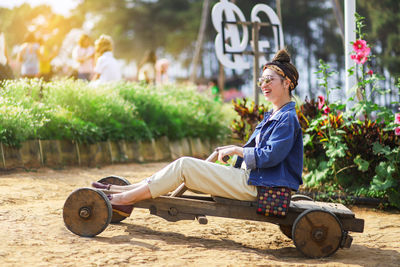 Side view of woman sitting outdoors