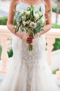 Midsection of woman holding flower bouquet