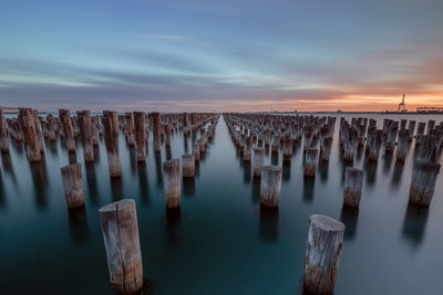 Panoramic view of wooden posts in sea against sky