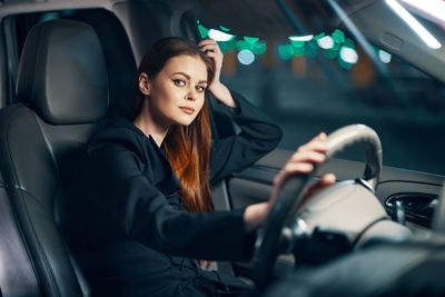 Portrait of young woman in car