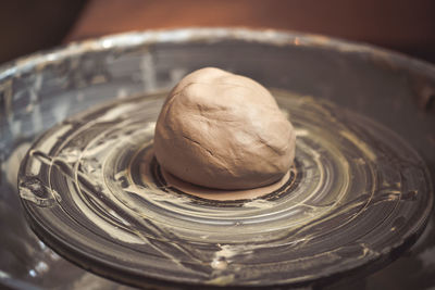 A piece of clay on a potter's wheel close-up in the pottery workshop