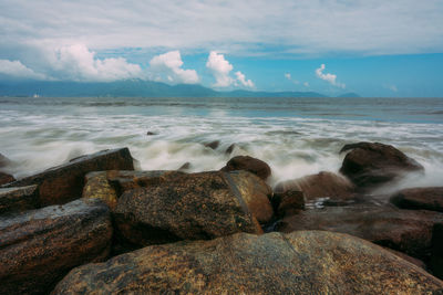 Scenic view of rocks on beach against sky