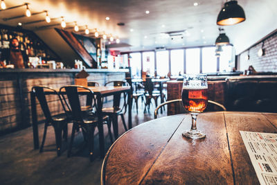 Wineglass with beer on wooden table at restaurant