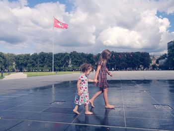Two girls barefoot in city square