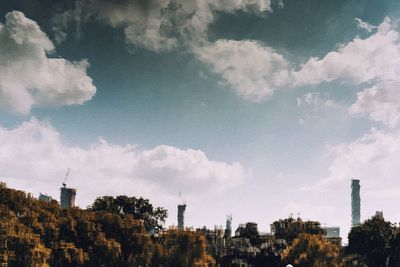 Low angle view of trees and buildings against sky