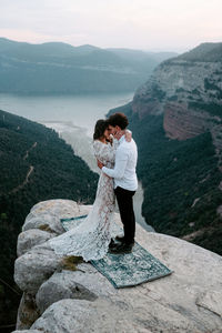 Full length of man standing on rock against mountains