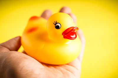 Close-up of hand holding yellow toy