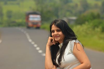 Portrait of woman using mobile phone on road