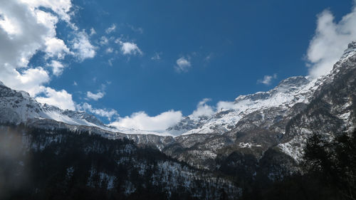 Low angle view of snowcapped mountains against sky