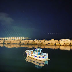 Boat moored on lake against sky at night