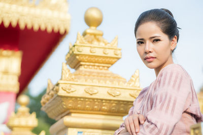 Portrait of woman standing by railing