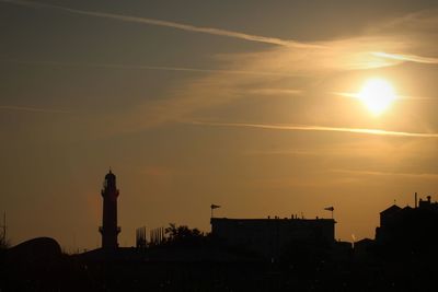 Silhouette buildings against sky during sunrise