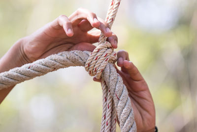 Close-up of hand tying rope 