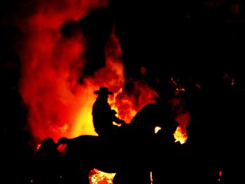 Silhouette of horse in fire at night