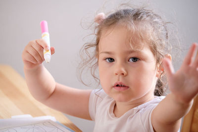 Little girl playing with invisible ink and coloring book