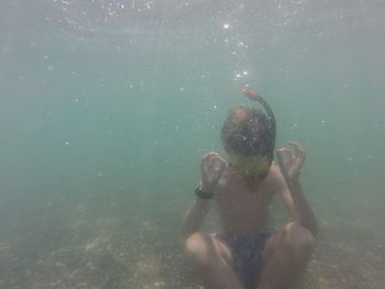 Shirtless boy swimming undersea
