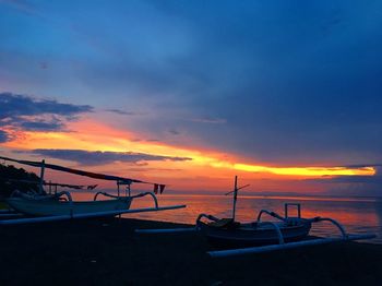 Boats moored in sea during sunset