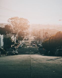 Cars on street in city against clear sky