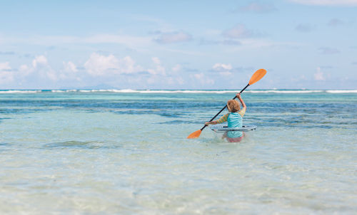 Man surfing in sea against sky