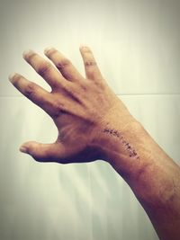 Close-up of man hand against wall