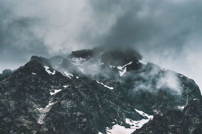 Low angle view of snowcapped mountains against sky