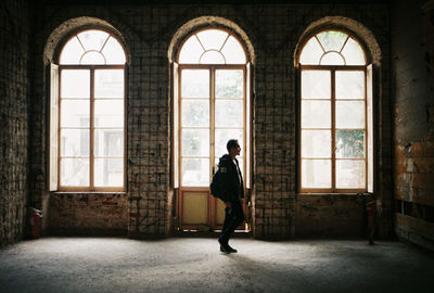 Side view of young man looking at building