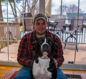 Portrait of woman with dog sitting outdoors