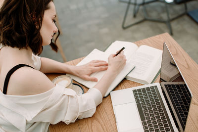 High angle view of woman using laptop on table