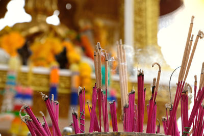 Burning incense and its smoke in front of blurred golden hindu lord brahma or phra phrom statue.